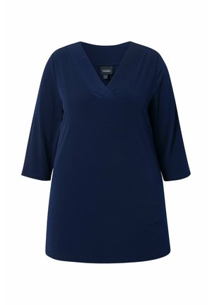Mørkeblå kvindetunika med trekvartlange ærmer og en V-formet halsudskæring, vist på en hvid baggrund.