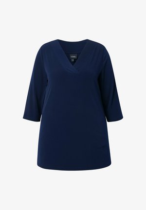 Donkerblauwe damestuniek met driekwartmouwen en een V-hals, afgebeeld op een witte achtergrond.