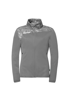 Veste de sport grise zippée avec col montant, épaules à motif géométrique et logo « Kempa » sur la poitrine gauche.