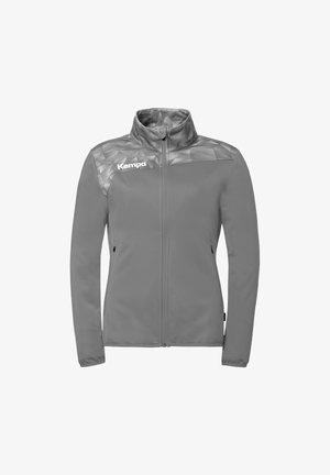 Grijze sportjas met rits, hoge kraag, schouders met geometrisch patroon en "Kempa" logo op de linkerborst.