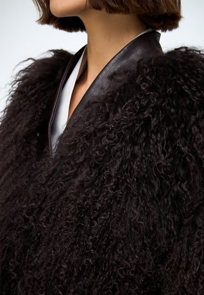 Czarna, kręcona, teksturowana odzież wierzchnia z kołnierzem i wykończeniem ze skóry, wyposażona w kontrastową warstwę wewnętrzną, prezentująca unikalny, przytulny design.