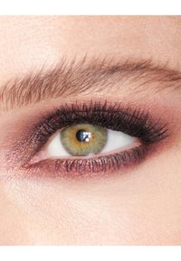 Close-up of a green eye with dark eyelashes, soft brow makeup, and a shimmering burgundy eyeshadow, highlighting detailed textures and colors.