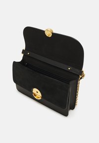 Borsa nera in suede e pelle con un pattina arrotondata. Presenta una chiusura circolare tono oro, una tracolla a catena e una tasca interna con zip.
