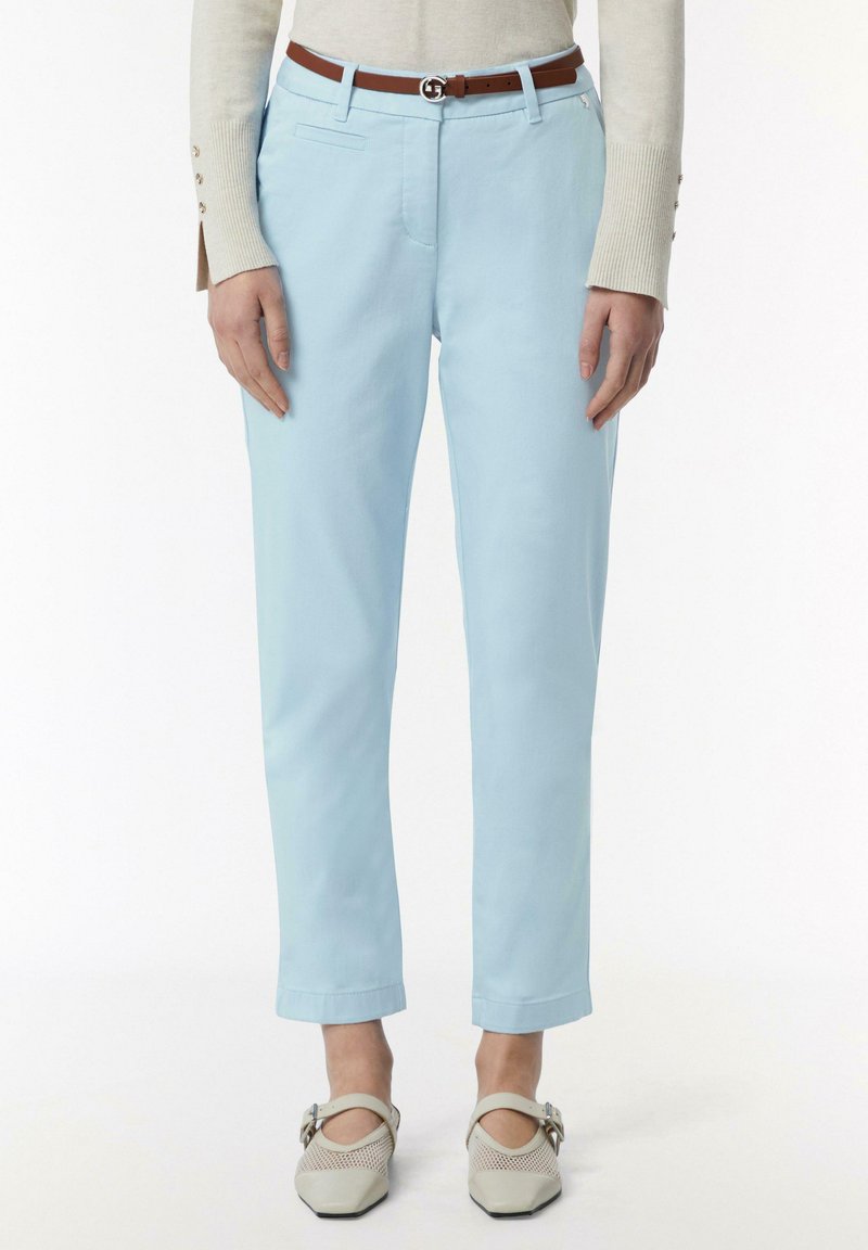 Lichtblauwe broek met een Slim fit, voorzien van zijzakken, een bruine riem met een metalen gesp, en opgerolde mouwen. Geverfde geweven stof.