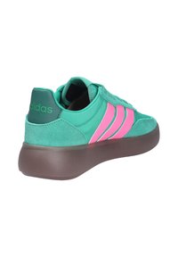 Baskets Adidas bleu sarcelle et rose en daim et tissu, semelle épaisse marron, avec logo Adidas sur la languette du talon.