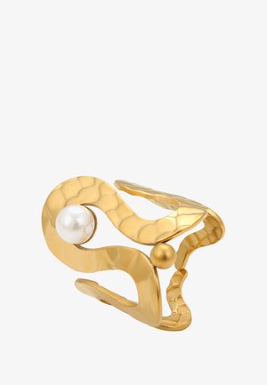 Arany, hullámos, nyitott gyűrű, kalapált textúrával, amelyen egy nagy fehér gyöngy és egy kisebb arany gyöngy található.