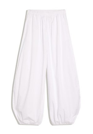 Ohlapne bele hlače z elastičnim pasom in elastičnimi manšetami, narejene iz lahkega blaga.