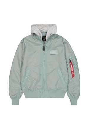 Chaqueta bomber verde claro con forro tipo sudadera gris, cremallera frontal, bolsillos laterales y detalle de etiqueta roja en la manga. Textura suave.