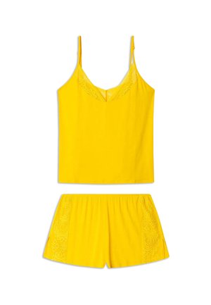 Ensemble de pyjama jaune comprenant un haut sans manches avec une dentelle et un short assorti avec des accents en dentelle sur les côtés. Fabriqué en tissu doux.