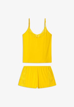 Ensemble de pyjama jaune comprenant un haut sans manches avec une dentelle et un short assorti avec des accents en dentelle sur les côtés. Fabriqué en tissu doux.