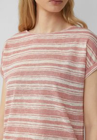 Gestreepte T-shirt in lichtroze en crème, gemaakt van een zachte, textuurrijke stof met een ontspannen pasvorm en korte mouwen.