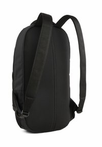 Sac à dos noir avec une surface en maille texturée, des bretelles rembourrées et une forme élancée. Comprend des compartiments zippés et des coutures renforcées.