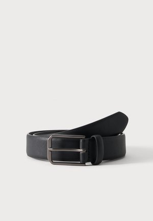 Ceinture en cuir noir roulée avec une boucle métallique argentée rectangulaire sur un fond clair uni.