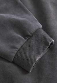 Dark gray sweatshirt fabric featuring a textured surface and a ribbed cuff. The cuff has a snug fit and smooth finish.