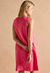 Helles pinkes ärmelloses Kleid mit orangefarbener Blumenstickerei. Gerader Schnitt mit einem knielangen Saum und subtiler Textur.