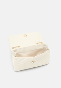 Kvadrovaná bílá kabelka na rukojeť s magnetickým uzávěrem, kovovými akcenty a hladkým interiérem s rozděleným oddílem.