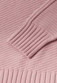 Miękka różowa dzianina z prążkowanym splotem, z zagiętym mankietem, ukazująca teksturowane pionowe i ukośne wzory prążków.