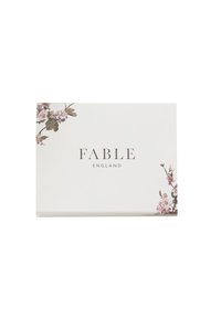 Caja rectangular blanca con el texto "FABLE ENGLAND" centrado, decorada con pequeñas ramas de flores rosas en la esquina superior izquierda y la esquina inferior derecha.