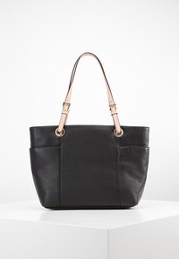 Svart läder tote väska med texturerad yta, med två sidofickor, ljusa remmar och detaljer i guldton. Rundad form.