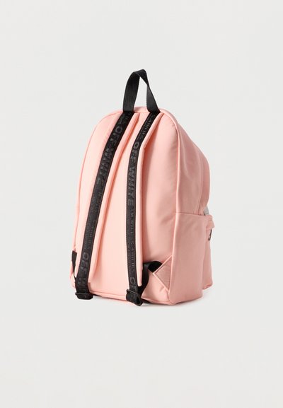 Ροζ σακίδιο με μαύρα ρυθμιζόμενα λουράκια και επάνω λουράκι για μεταφορά, εμφανίζεται από πίσω σε λευκό φόντο.