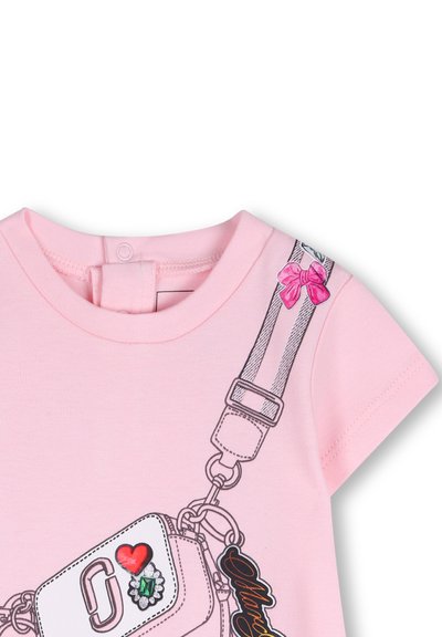 Różowy bawełniany t-shirt z krótkim rękawem, ilustrowanym paskiem z kokardkami oraz dekoracyjnymi naszywkami, w tym sercem i napisem.