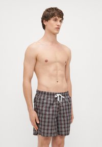 Καρό μαγιό σε καφέ, μπλε και λευκό χρώμα. Φτιαγμένα από ελαφρύ ύφασμα με ελαστική μέση και κορδόνι για ρύθμιση.