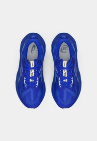 Blå idrettssko med en pustende mesh-overdel, mønstrete design, hvite lisser og en polstret såle. Logo synlig på siden.