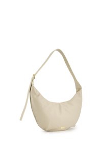 Beige Leder Schultertasche mit einer geschwungenen Form, flexiblem Design und verstellbarem Riemen. Mit einem kleinen goldenen Logodetail.