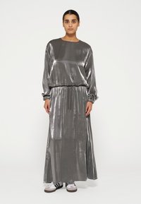 Silberne, metallisch schimmernde Langarmkleid mit einem elastischen Taillenbund und gerafften Bündchen, das über eine lässige Passform und eine glatte, glänzende Textur verfügt.