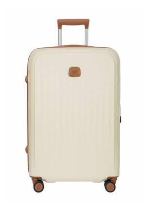 Cream-colored hard-shell suitcase with brown leather accents, retractable handle, four spinner wheels, and a small front logo patch.