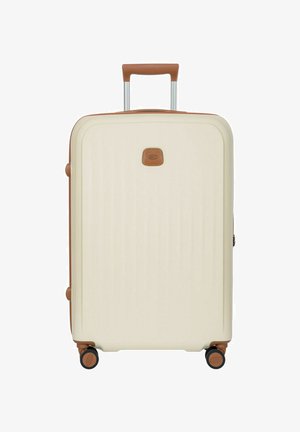 Valigia rigida color crema con dettagli in pelle marrone, manico retrattile, quattro ruote pivotanti e piccolo logo frontale.