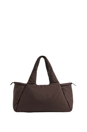 Sac cabas matelassé brun foncé avec deux poignées et poches latérales zippées, conçu avec une texture douce, matelassée et une forme structurée.