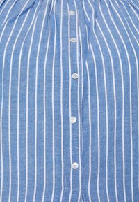 Camicia a righe blu e bianche con bottoni, realizzata in un tessuto leggero, caratterizzata da bottoni bianchi, colletto dritto e una vestibilità morbida.