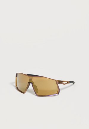 Sportliche, kantige Sonnenbrille mit braun getönten Gläsern und transparentem bernsteinfarbenem Rahmen, schwarze strukturierte Bügelenden.
