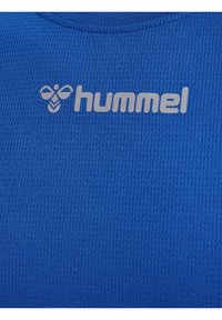 Blaues Sporttrikot aus einem strukturierten, atmungsaktiven Stoff. Das Logo "hummel" und eine Biene sind in einem kontrastierenden hellen Grauton aufgedruckt.