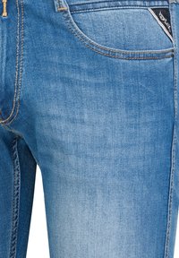 Lichtblauwe denim jeans met een lichte vervaging, standaard vijf-pocket ontwerp, contrasterende stiksels en een klein merkembleem op de tailleband.