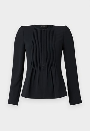 Blouse noire à manches longues avec des plis verticaux à l'avant, col rond et taille cintrée, fabriquée dans un tissu lisse.