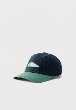 Gorra de béisbol azul marino con una visera curva verde y un parche con un logo de ola verde en el panel frontal, mostrada sobre un fondo blanco.