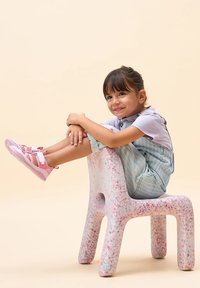 Sedia per bambini realizzata in materiale bianco maculato con spruzzi colorati. Bordo arrotondato, gambe spesse, area di seduta liscia e sagomata.