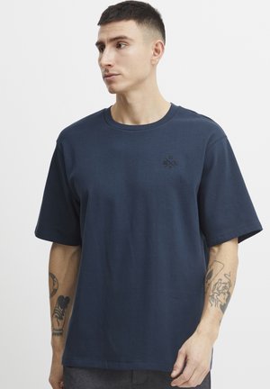 Navy blue cotton t-shirt with short sleeves, round neck, and a subtle logo on the chest. Smooth texture and relaxed fit.