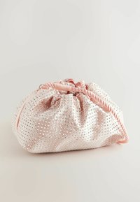 Ružový zamatový drawstring vak s textúrovaným povrchom, ozdobený malými striebornými cvokmi, s zodpovedajúcou spirálovou šnúrkou na zatváranie.