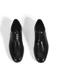 Zwarte leren dresschoenen met een gladde textuur, vetersluiting, ronde neus en subtiele stikdetails. De zool is elegant en gepolijst.