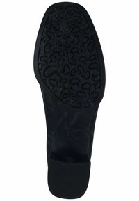 Semelle de chaussure noire avec un motif de grip texturé, présentant des lignes courbes. Matériau en caoutchouc lisse avec un léger éclat et un logo gravé.