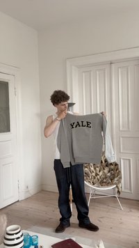 Szürke pulóver, elöl nagyméretű, fekete "YALE" felirattal, hosszú ujjal és kontrasztos díszítéssel. Puha anyag, laza szabású.