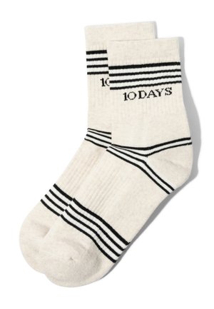 Calcetines blancos de tripulación con rayas horizontales negras en los puños, tobillos y dedos, con el texto "10 DAYS" en el puño superior.