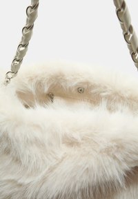 Faux fur håndtaske med en blød, fluffy tekstur i cremefarve, med en flet kædestrop og indvendig lynlåslomme til opbevaring.