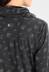 Ciemnoszara bluza z kapturem o miękkiej fakturze, z wzorem zielonych liści miłorzębu, z kołnierzem typu cowl oraz małym metalowym akcentem z logo.