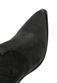 Black suede ankle boot with a pointed toe, stitched detailing, and a smooth texture. Rubber sole with a slight lift at the heel.
