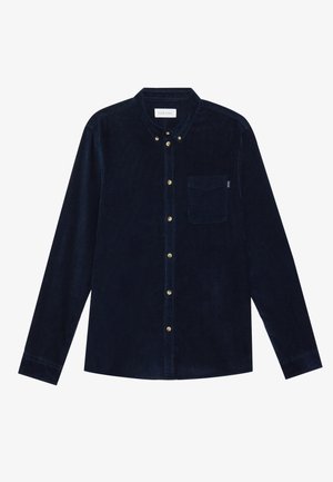 Camisa de pana navy con mangas largas, cuello abotonado, bolsillo en el pecho y botones dorados. Textura suave y corte entallado.