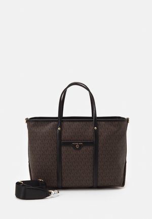 Brązowa torba typu tote Michael Kors z czarnymi uchwytami, przednią kieszenią i odpinanym paskiem na ramię na białym tle.